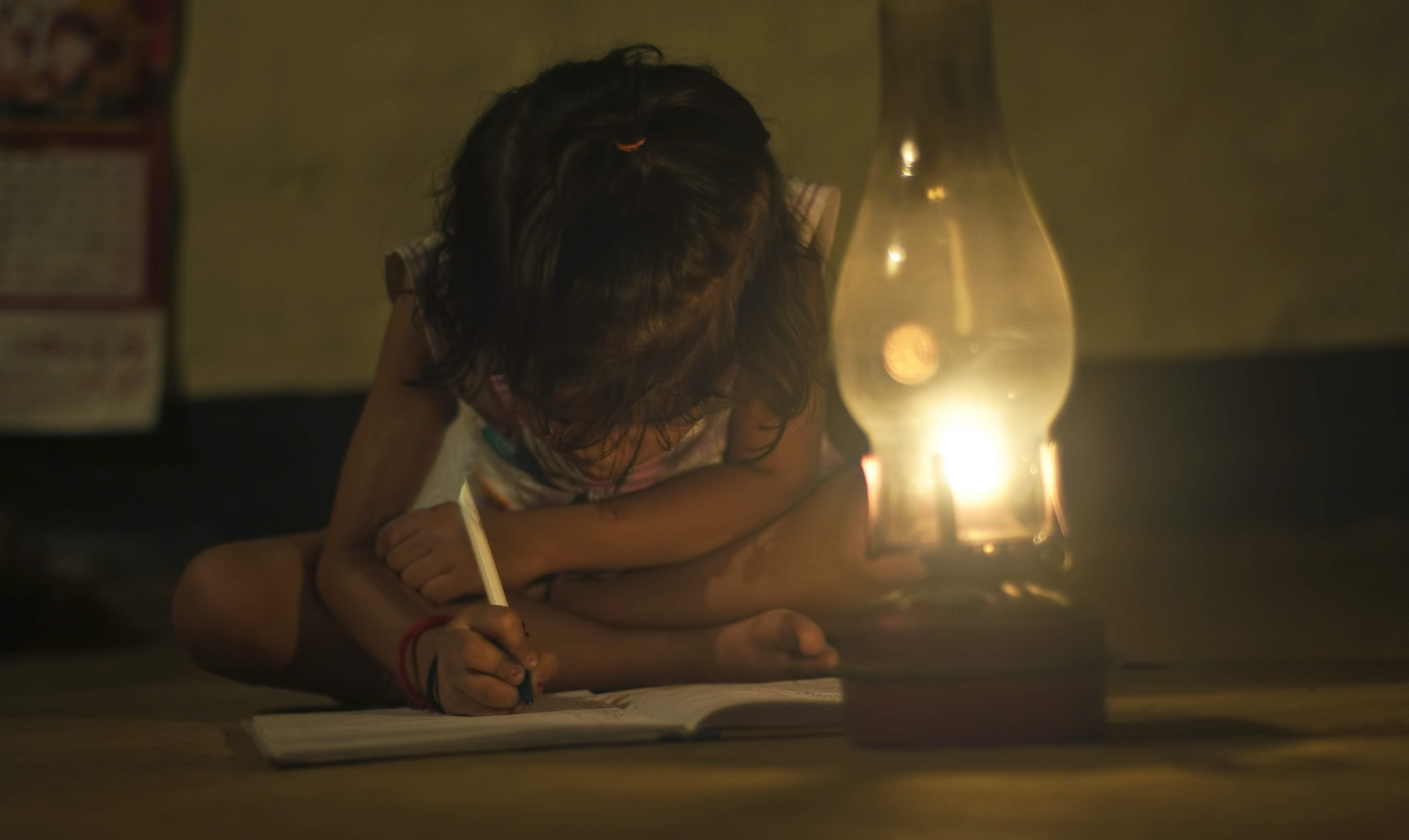 There is poor woman with five children. Poor book reading. Books under Lights. Kid studying and Lamp. Book under Lamp.