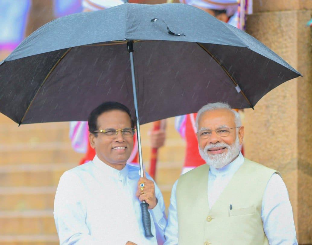Sri Lanka president holds up umbrella for Modi during rains. See photo